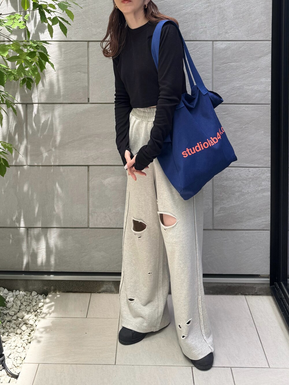 グレー系のスウェットパンツ、ブラック系のTシャツ/カットソー、ブラック系のスニーカーを着用したレディースの春コーディネートの3枚目の写真