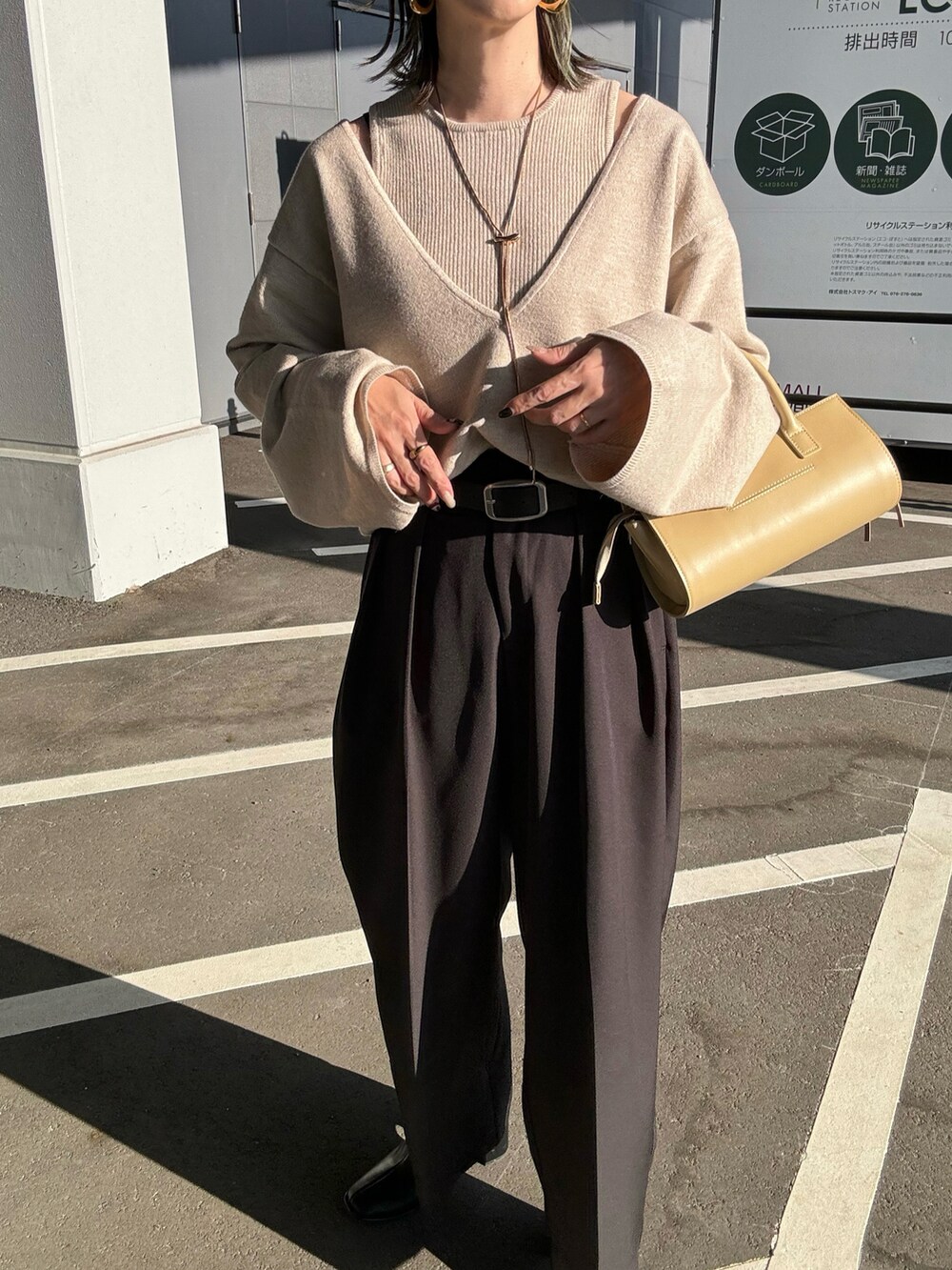 ベージュ系のニット/セーター、ブラック系のその他パンツ、ベージュ系のハンドバッグを着用したレディースの秋コーディネートの4枚目の写真