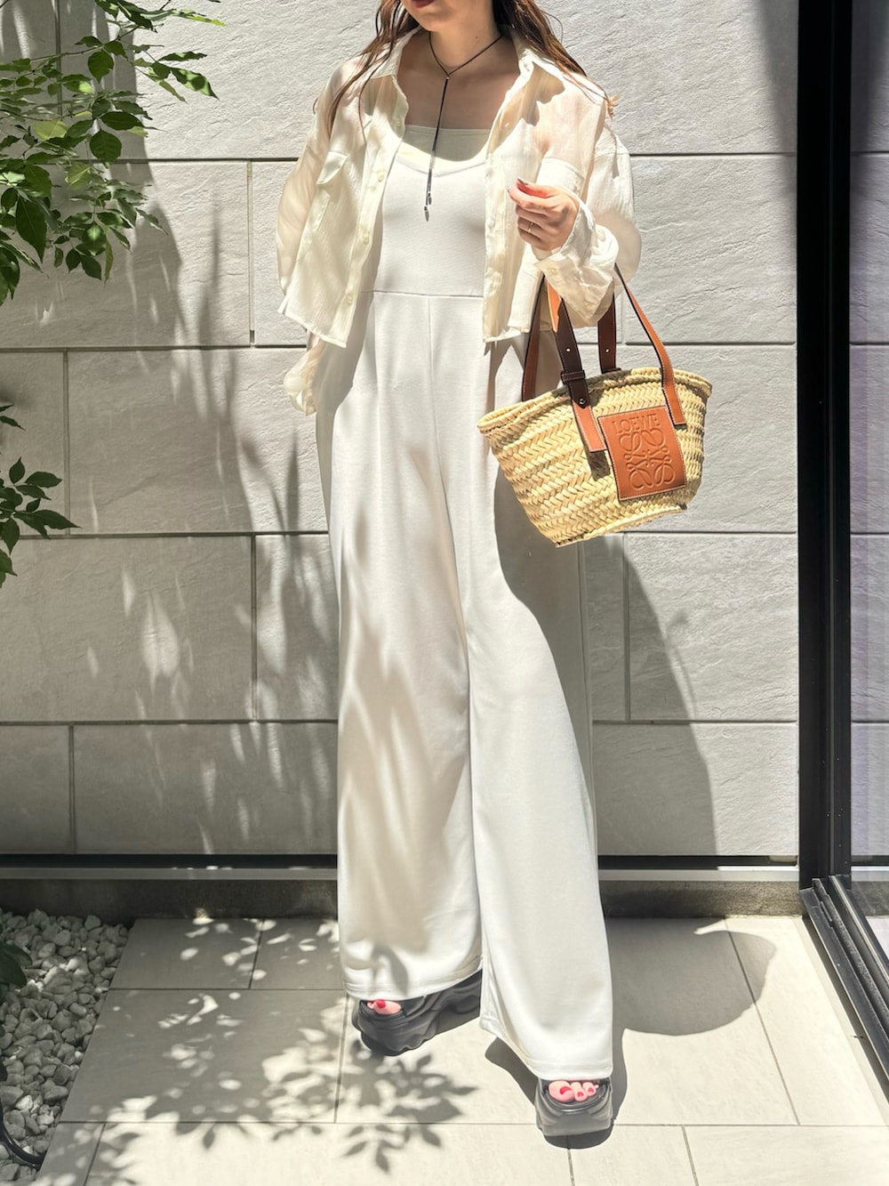 ホワイト系のシャツ/ブラウス、ブラック系のサンダル、ブラウン系のトートバッグを着用したレディースの夏コーディネートの3枚目の写真