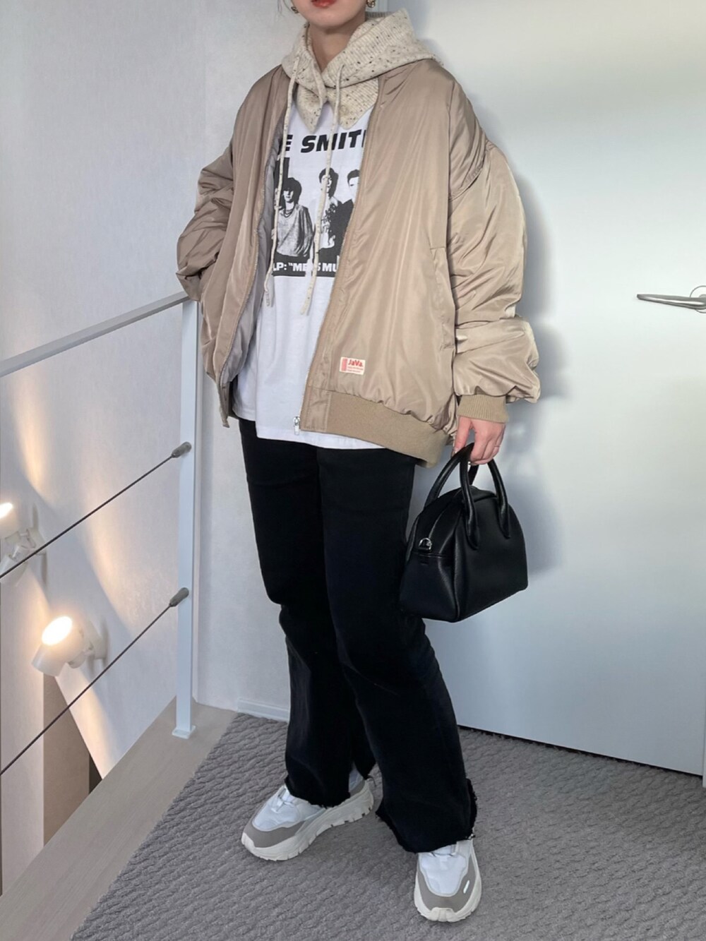 ベージュ系のMA-1、ホワイト系のスニーカー、ブラック系のボストンバッグを着用したレディースの冬コーディネートの3枚目の写真