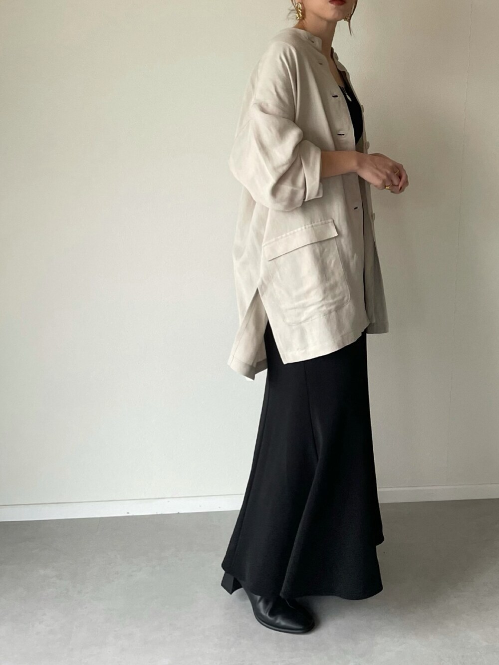 ベージュ系のその他アウター、ブラック系のスカート、ブラウン系のショルダーバッグを着用したレディースの冬コーディネートの2枚目の写真