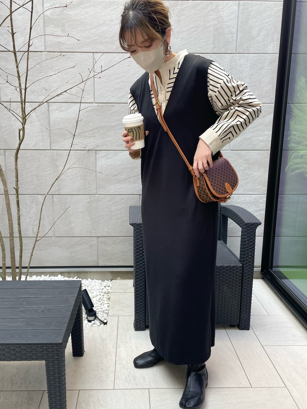 ブラック系のワンピース、ホワイト系のシャツ/ブラウスを着用したレディースの春コーディネートの3枚目の写真