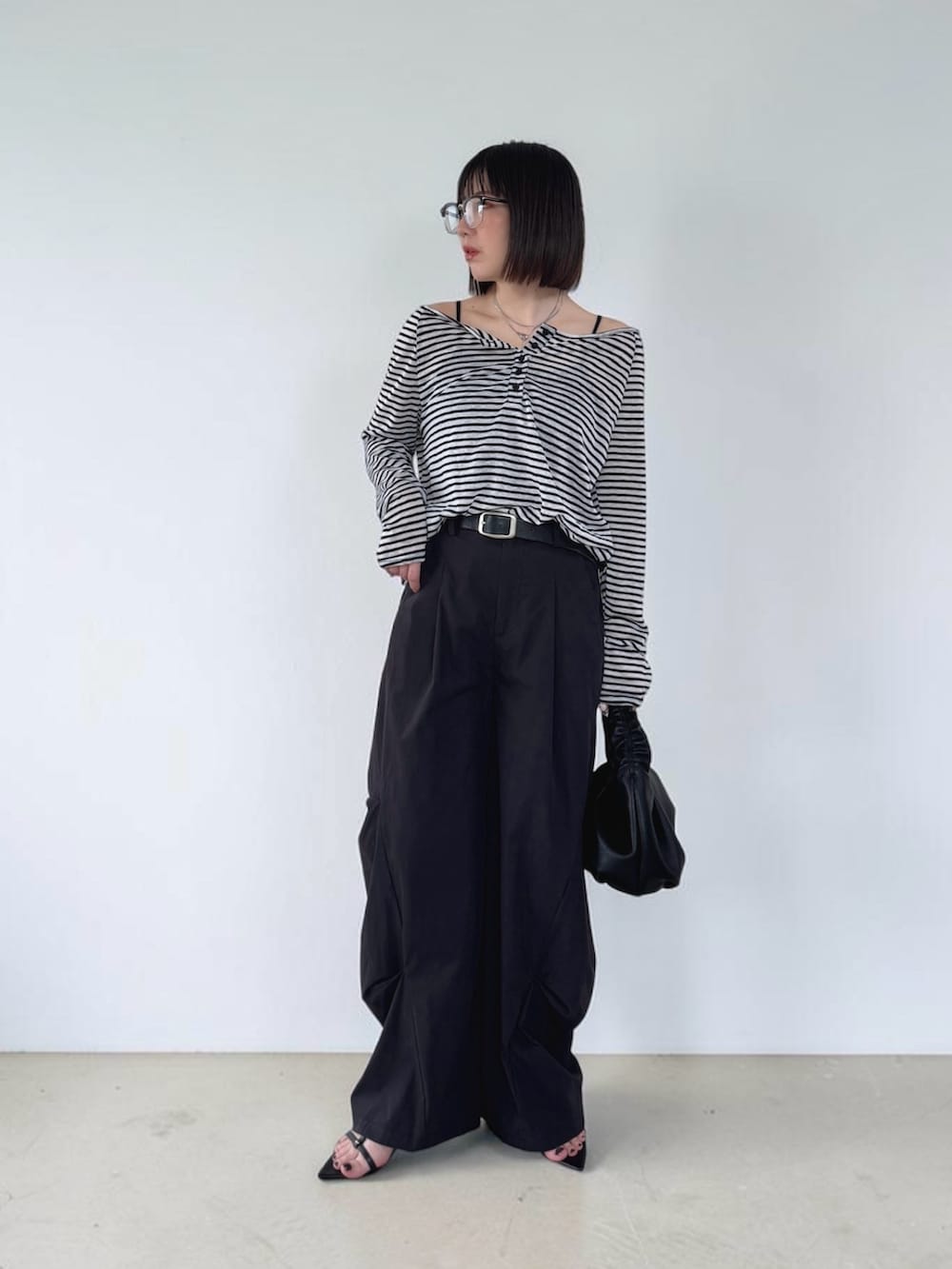 ブラック系のサンダル、ブラック系のその他パンツ、ブラック系のショルダーバッグを着用したレディースの春コーディネートの2枚目の写真
