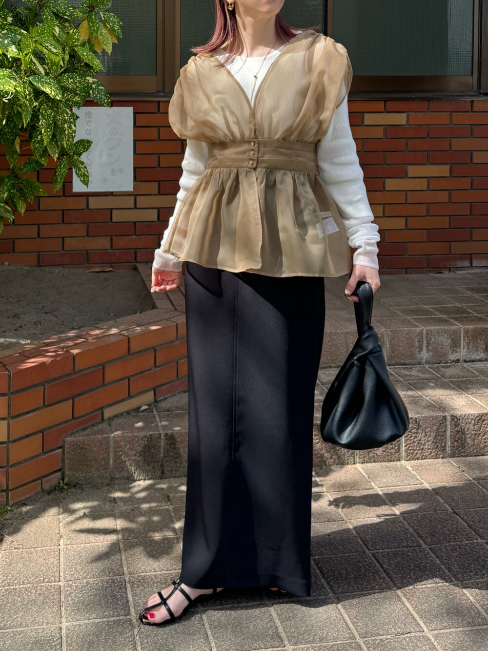 ベージュ系のTシャツ/カットソー、ブラック系のサンダル、ブラック系のスカートを着用したレディースの春コーディネートの2枚目の写真