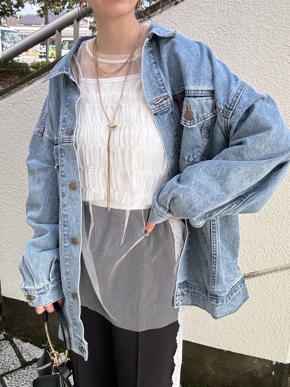 ブルー系のデニムジャケット、ブラック系のその他パンツ、ブラック系のハンドバッグを着用したレディースの冬コーディネートの5枚目の写真