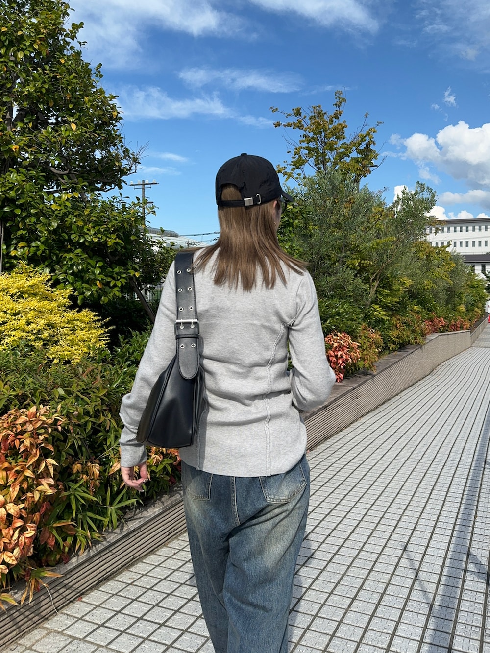 グレー系のカーディガン/ボレロ、ブルー系のデニムパンツ、ブラック系のハンドバッグを着用したレディースの夏コーディネートの5枚目の写真