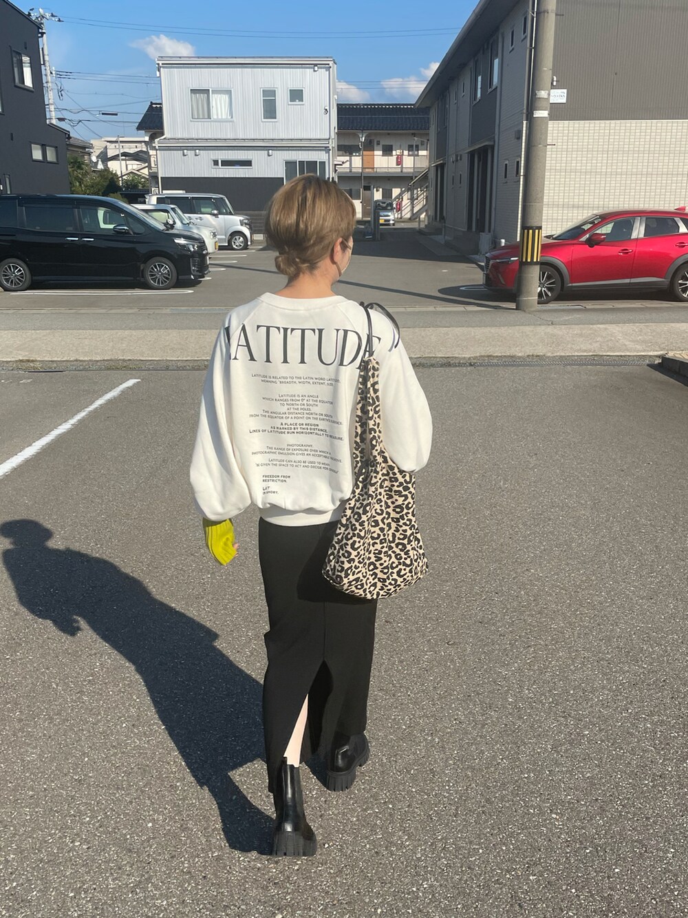 ホワイト系のスウェット、ブラック系のブーツ、ブラック系のスカートを着用したレディースの秋コーディネートの3枚目の写真