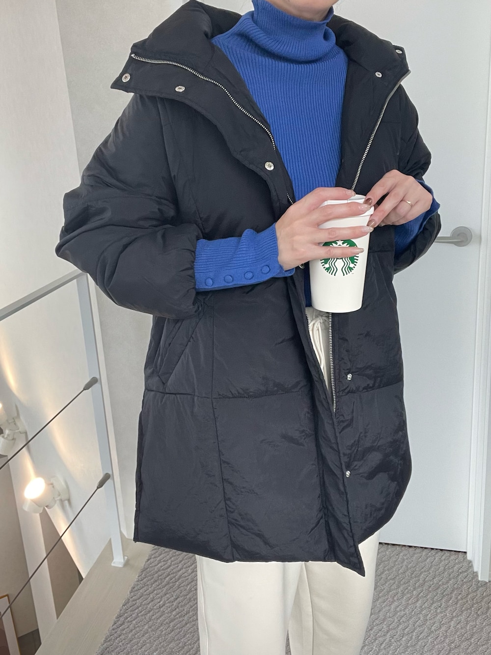 ブラック系のダウンジャケット/コート、ブルー系のニット/セーターを着用したレディースの冬コーディネートの2枚目の写真