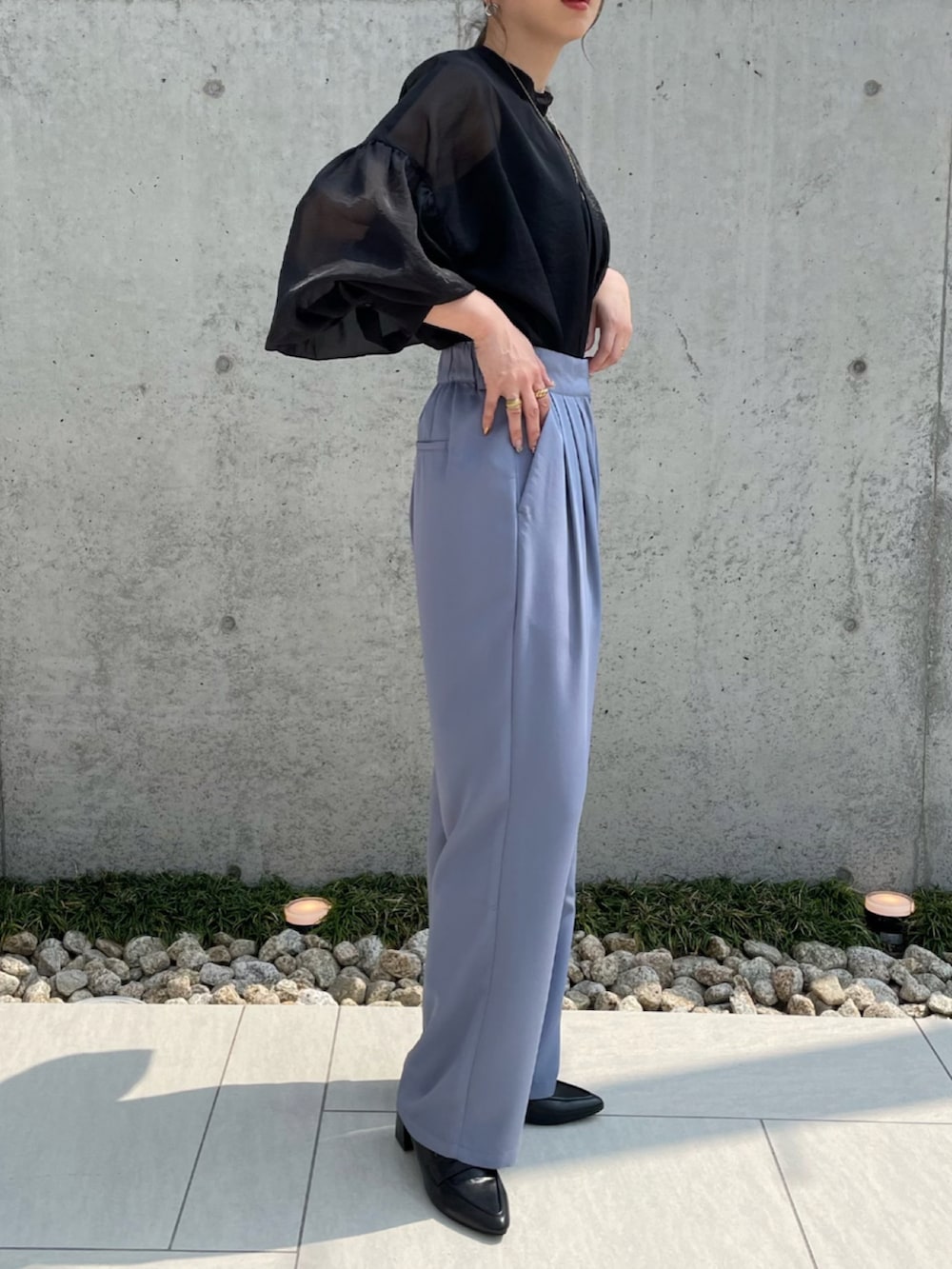 ブルー系のスラックス、ブラック系のシャツ/ブラウス、ブラック系のローファーを着用したレディースの夏コーディネートの3枚目の写真