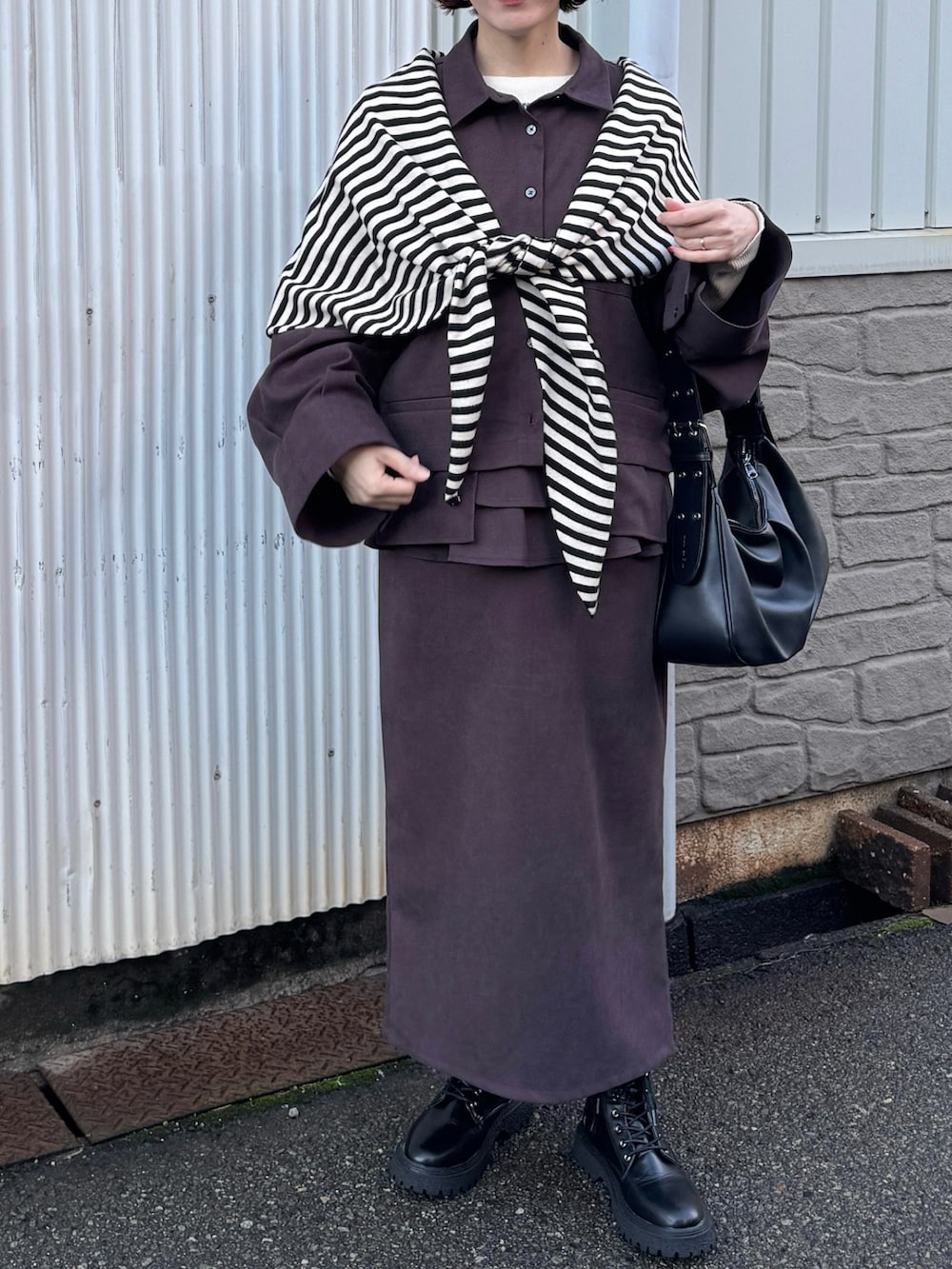 ブラウン系のシャツ/ブラウス、ブラウン系のスカート、ブラック系のハンドバッグを着用したレディースの秋コーディネートの2枚目の写真