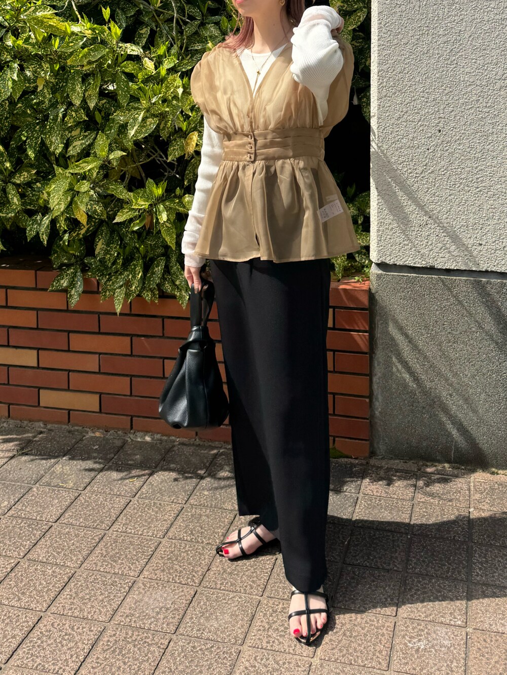ベージュ系のTシャツ/カットソー、ブラック系のサンダル、ブラック系のスカートを着用したレディースの春コーディネートの4枚目の写真