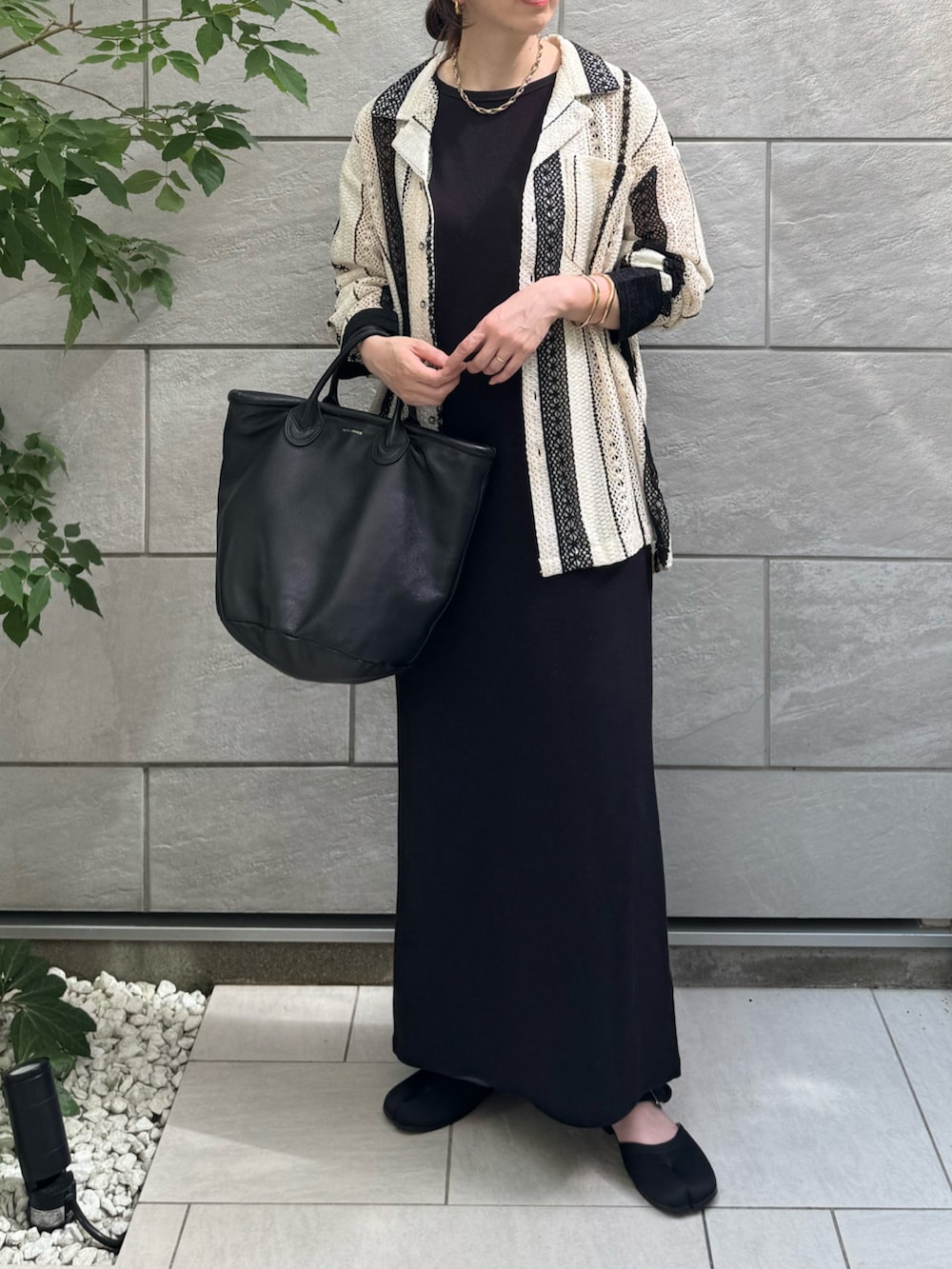 ホワイト系のシャツ/ブラウス、ブラック系のワンピース、ブラック系のサンダルを着用したレディースの夏コーディネートの3枚目の写真