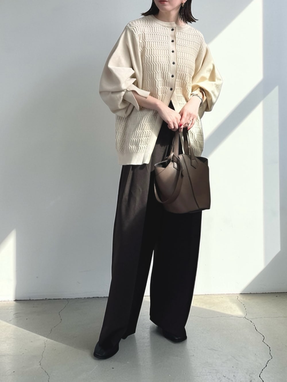 ブラウン系のその他パンツ、ホワイト系のカーディガン/ボレロ、ブラウン系のショルダーバッグを着用したレディースの春コーディネートの2枚目の写真