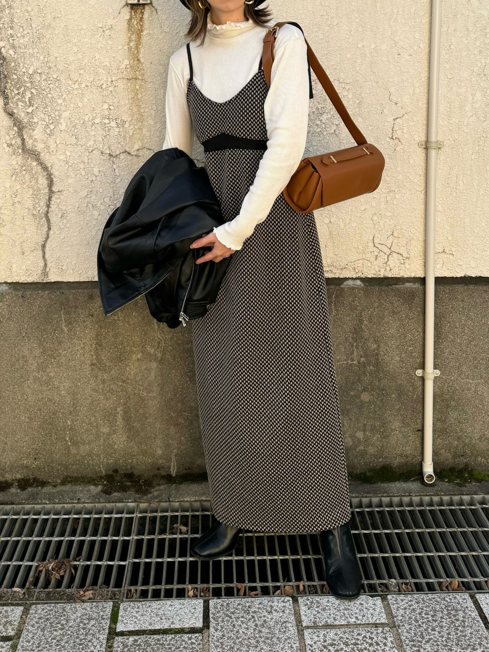 ホワイト系のTシャツ/カットソー、ブラック系のワンピース、ブラック系のライダースジャケットを着用したレディースの冬コーディネートの4枚目の写真