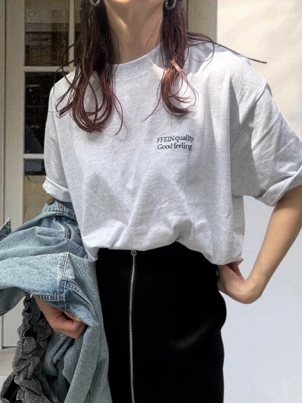 グレー系のTシャツ/カットソー、ブルー系のデニムジャケット、ブラック系のスカートを着用したレディースの春コーディネートの2枚目の写真