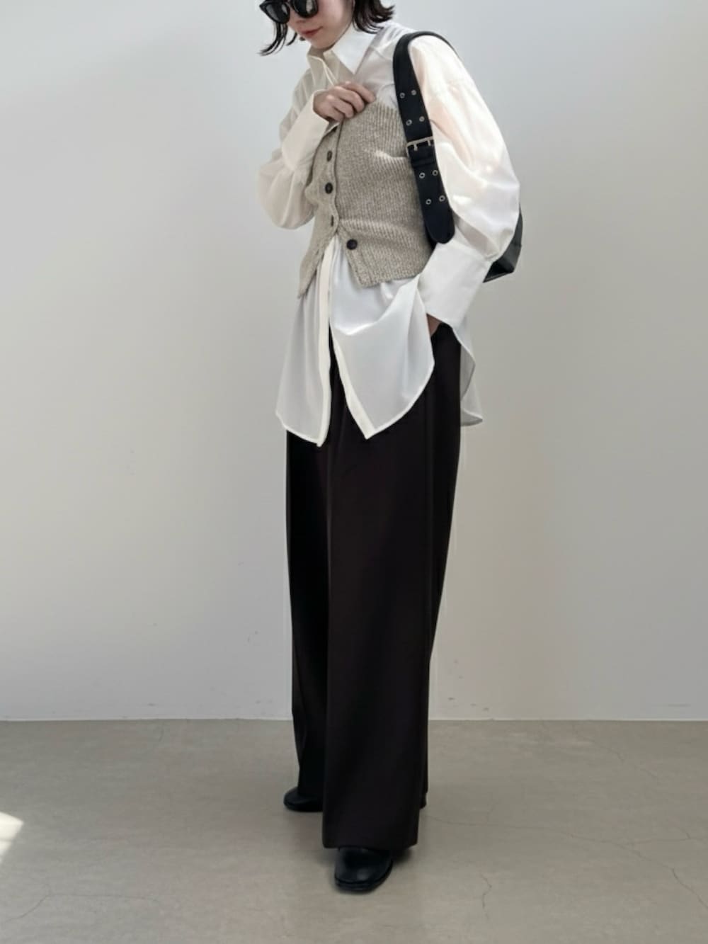 ブラウン系のその他パンツ、ブラック系のハンドバッグ、ベージュ系のベストを着用したレディースの冬コーディネートの3枚目の写真