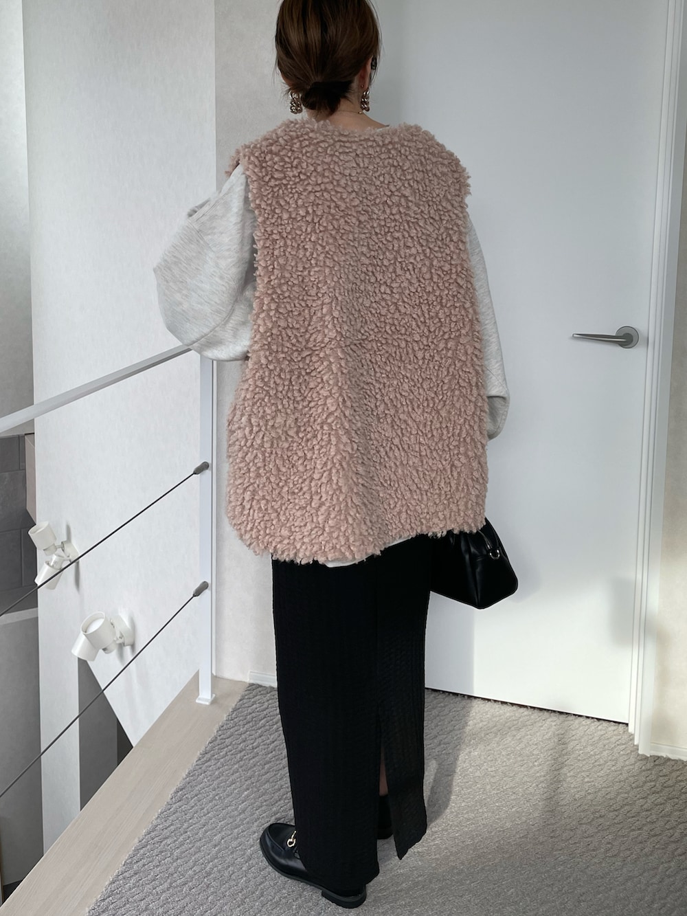 ベージュ系のベスト、ブラック系のスカート、ベージュ系のスウェットを着用したレディースの冬コーディネートの4枚目の写真