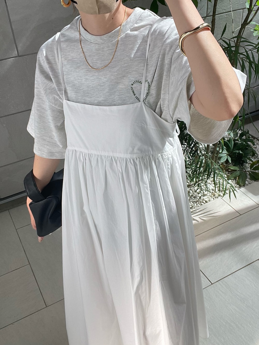 ホワイト系のワンピース、ブラック系のサンダルを着用したレディースの春コーディネートの5枚目の写真