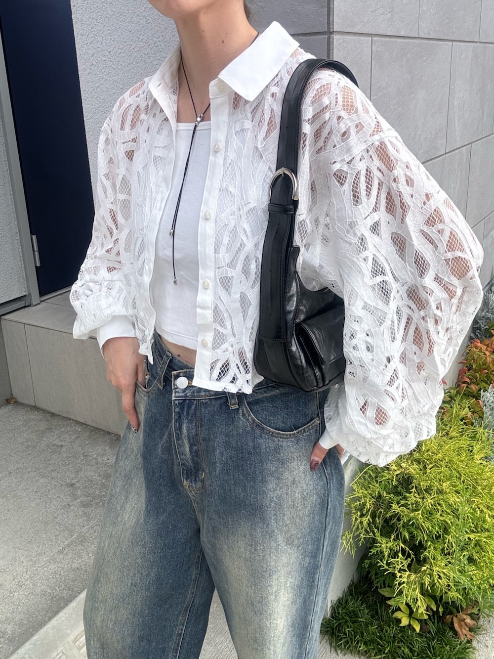 ブルー系のデニムパンツ、ブラック系のショルダーバッグ、ブラック系のスニーカーを着用したレディースの夏コーディネートの5枚目の写真