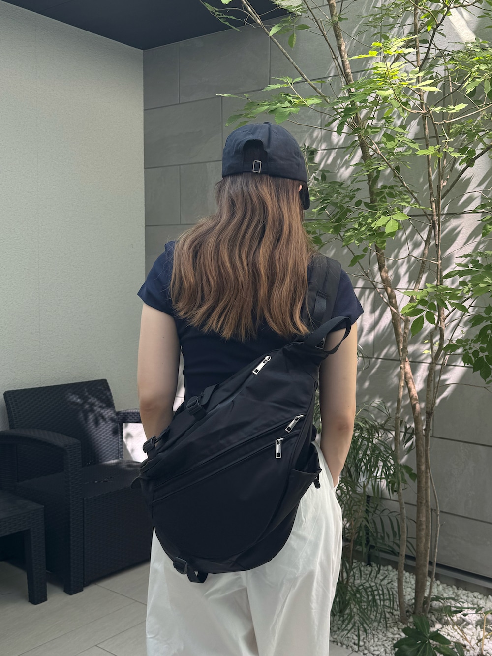 ブラック系のスニーカー、ホワイト系のその他パンツ、ブラック系のボディバッグ/ウエストポーチを着用したレディースの夏コーディネートの5枚目の写真