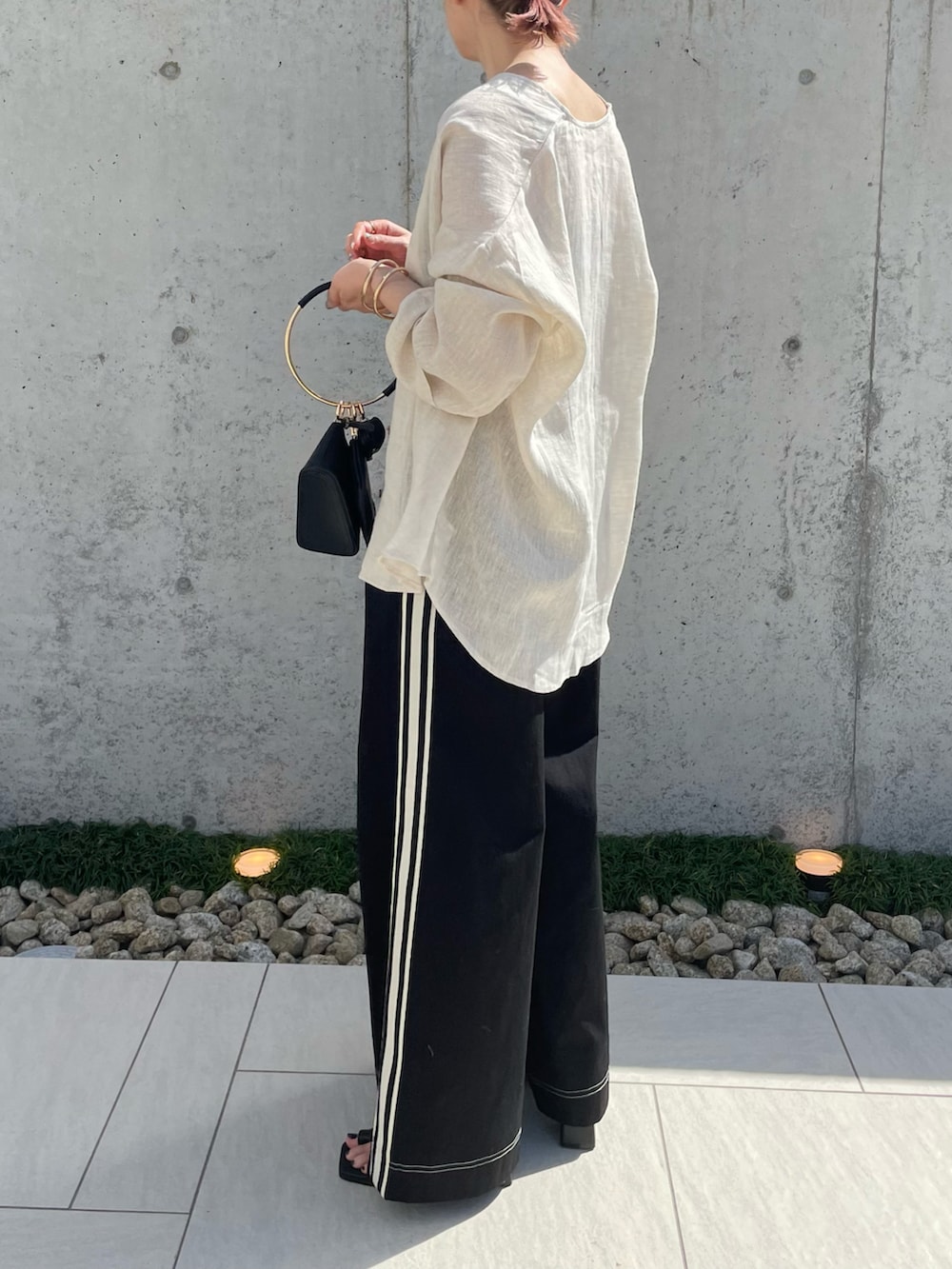 ベージュ系のシャツ/ブラウス、ブラック系のチノパンツ、ブラック系のハンドバッグを着用したレディースの春コーディネートの3枚目の写真