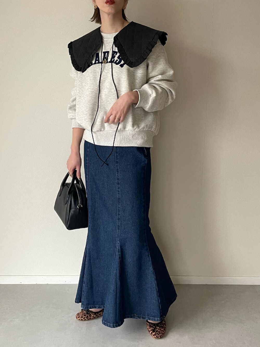 ブラック系のボストンバッグ、その他のバレエシューズ、ブルー系のスカートを着用したレディースの春コーディネートの2枚目の写真