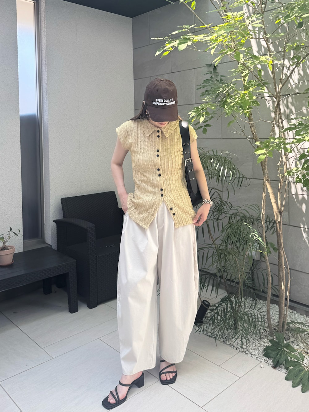 ベージュ系のカーディガン/ボレロ、ホワイト系のチノパンツ、ブラック系のサンダルを着用したレディースの夏コーディネートの2枚目の写真