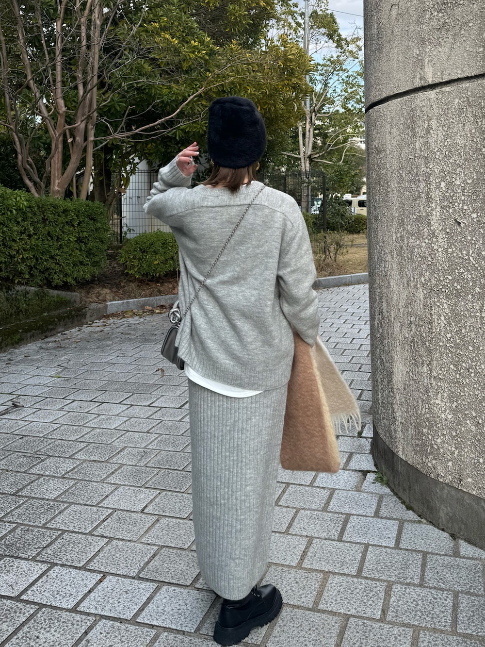 グレー系のワンピース、ブラック系のライダースジャケット、シルバー系のショルダーバッグを着用したレディースの冬コーディネートの5枚目の写真