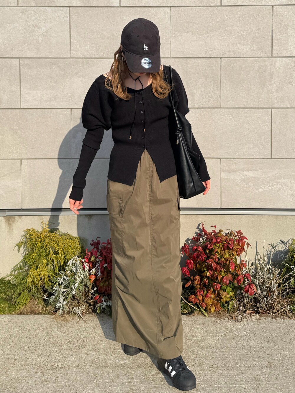 ブラック系のカーディガン/ボレロ、グリーン系のスカート、ブラック系のショルダーバッグを着用したレディースの春コーディネートの3枚目の写真