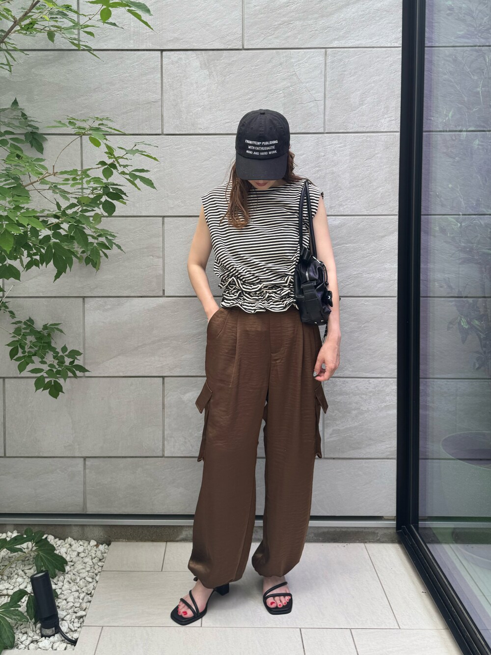 ブラウン系のその他パンツ、ブラック系のTシャツ/カットソー、ブラック系のボストンバッグを着用したレディースの夏コーディネートの2枚目の写真