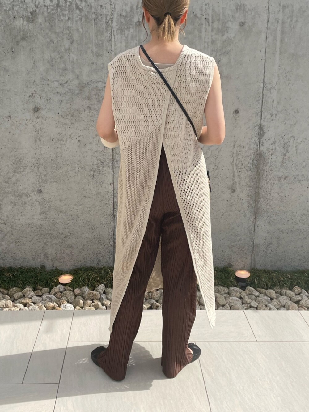 ホワイト系のニット/セーター、ブラック系のショルダーバッグ、ブラック系のパンプスを着用したレディースの春コーディネートの5枚目の写真