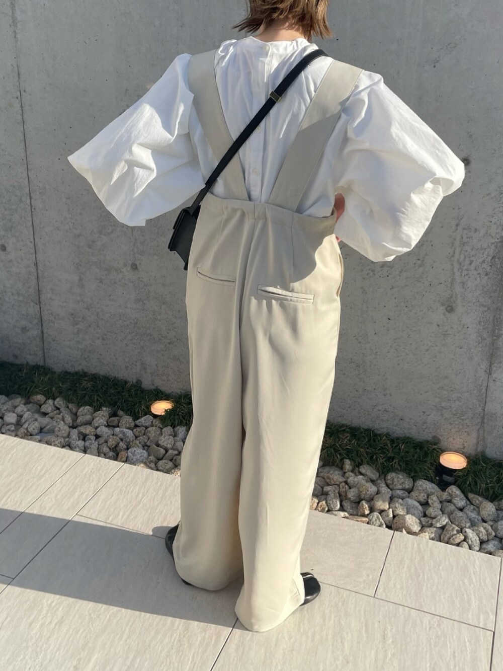 ホワイト系のサロペット/オーバーオール、ホワイト系のシャツ/ブラウス、ブラック系のパンプスを着用したレディースの春コーディネートの4枚目の写真