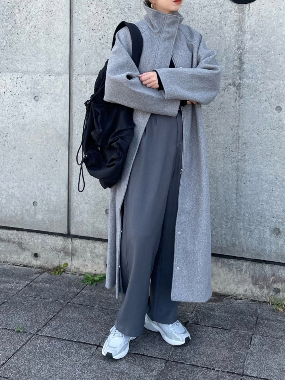 グレー系のセットアップ、グレー系のスニーカー、ブラック系のバックパック/リュックを着用したレディースの秋コーディネートの3枚目の写真