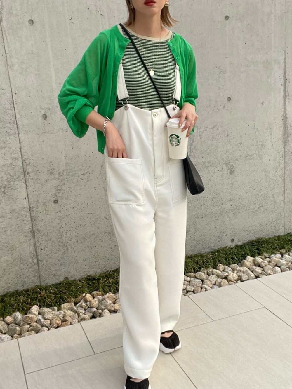 グリーン系のタンクトップ、グリーン系のカーディガン/ボレロ、ブラック系のショルダーバッグを着用したレディースの春コーディネートの3枚目の写真