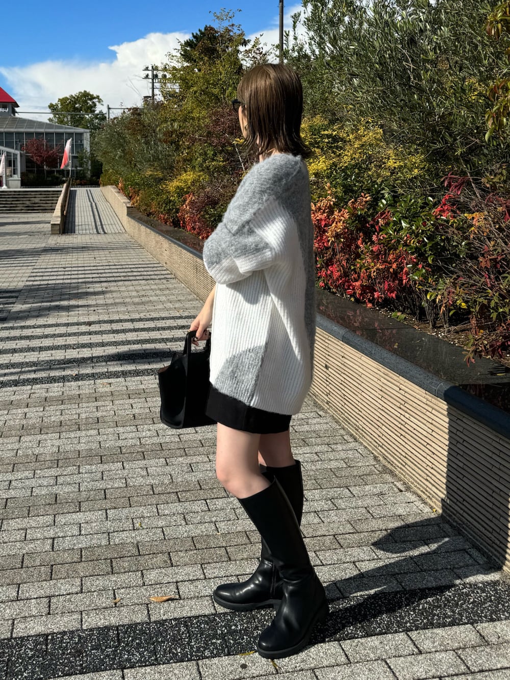 ブラック系のその他パンツ、ブラック系のハンドバッグ、ホワイト系のキャミソールを着用したレディースの秋コーディネートの4枚目の写真