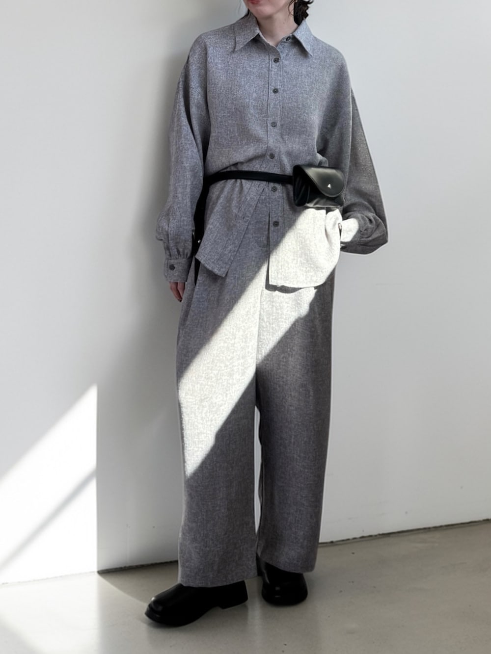 グレー系のシャツ/ブラウス、グレー系のスラックス、ブラック系のその他シューズを着用したレディースの春コーディネートの2枚目の写真