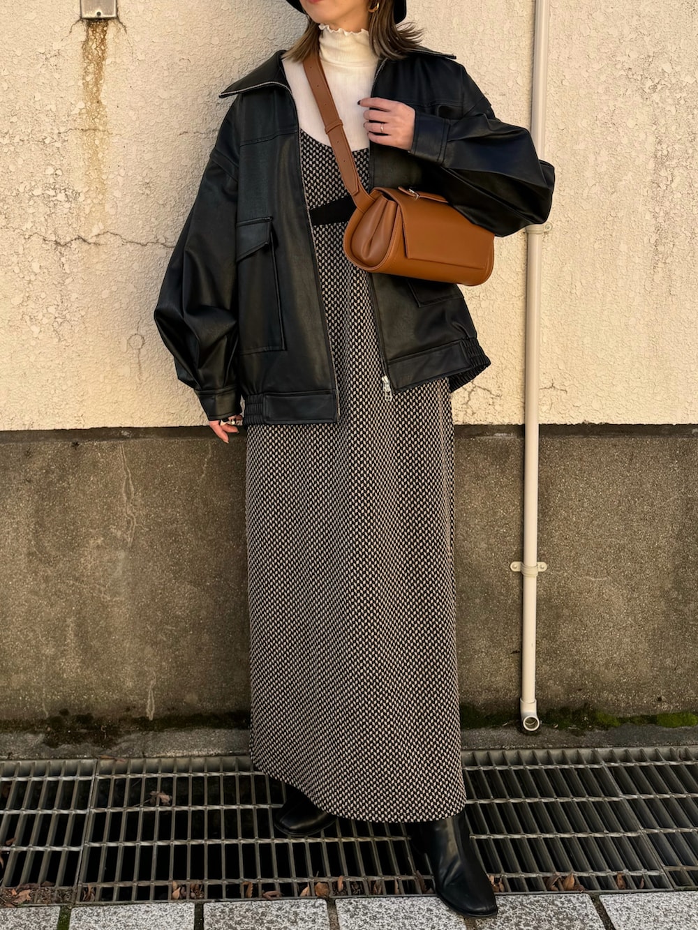 ホワイト系のTシャツ/カットソー、ブラック系のワンピース、ブラック系のライダースジャケットを着用したレディースの冬コーディネートの2枚目の写真