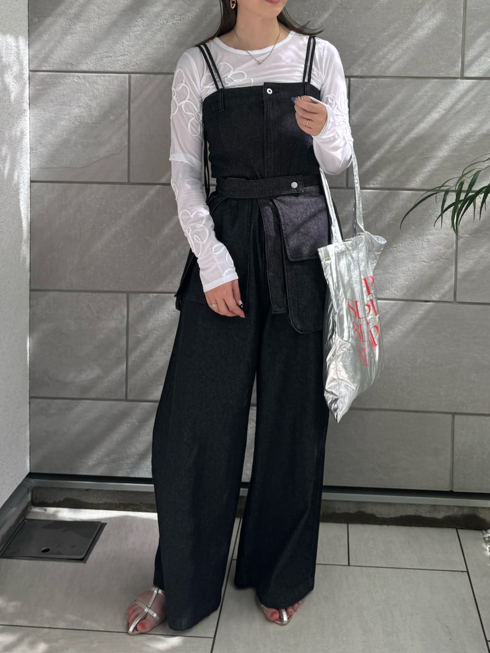 ブラック系のサロペット/オーバーオール、シルバー系のトートバッグ、シルバー系のサンダルを着用したレディースの夏コーディネートの2枚目の写真