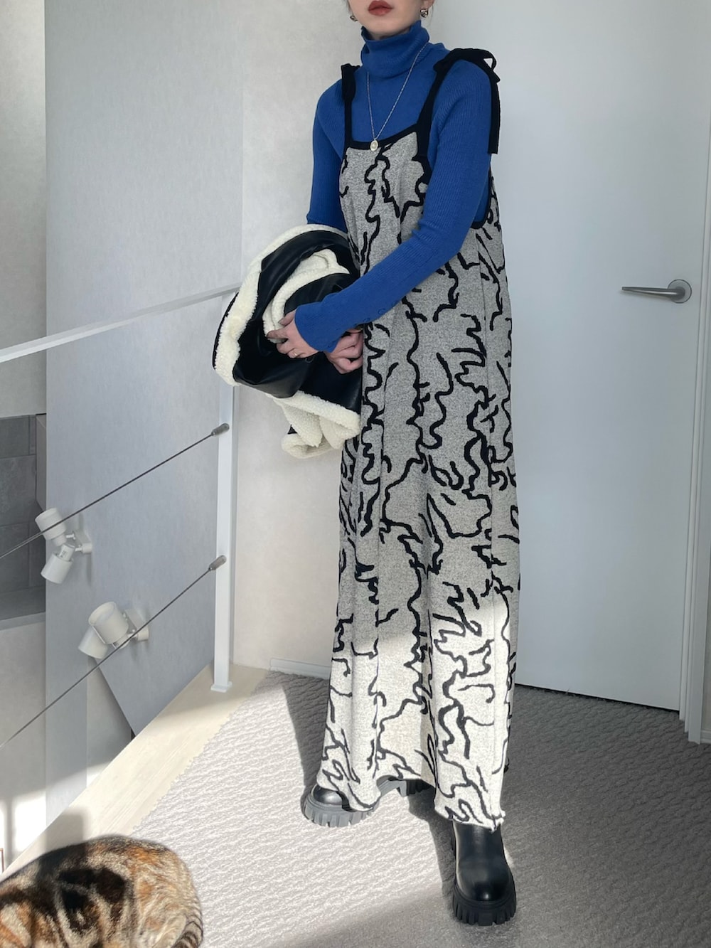 ブルー系のニット/セーター、ホワイト系のワンピース、ブラック系のベストを着用したレディースの冬コーディネートの4枚目の写真