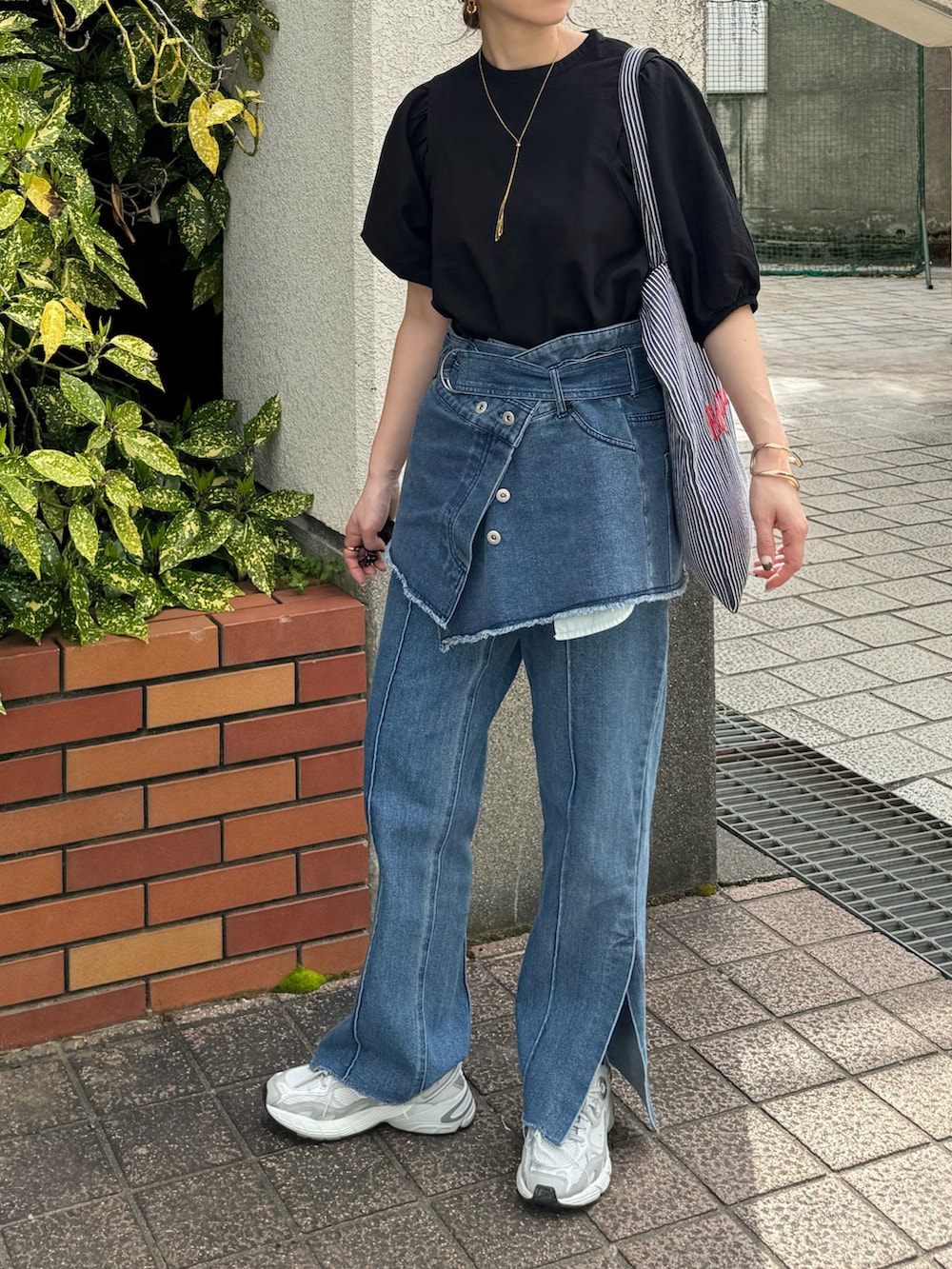 ブラック系のシャツ/ブラウス、ブラック系のトートバッグ、ブルー系のデニムパンツを着用したレディースの春コーディネートの3枚目の写真