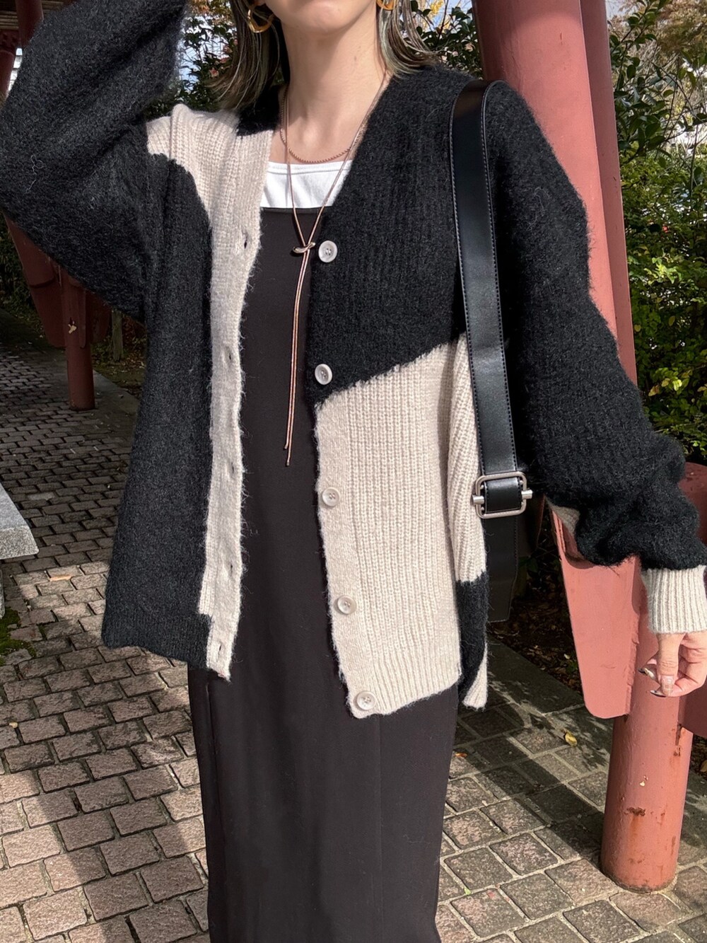 ブラック系のカーディガン/ボレロ、ゴールド系のネックレスを着用したレディースの冬コーディネートの5枚目の写真