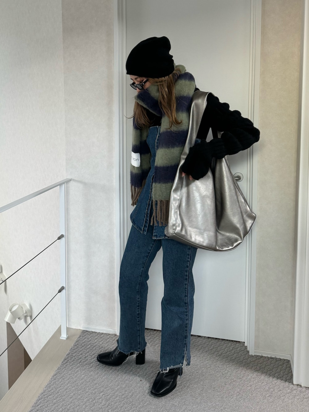 ブルー系のデニムパンツ、シルバー系のトートバッグ、ブルー系のデニムパンツを着用したレディースの冬コーディネートの3枚目の写真