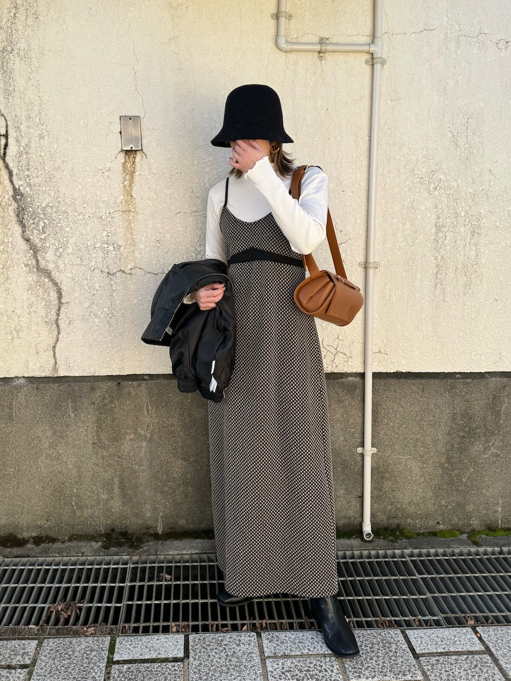 ホワイト系のTシャツ/カットソー、ブラック系のワンピース、ブラック系のライダースジャケットを着用したレディースの冬コーディネートの3枚目の写真