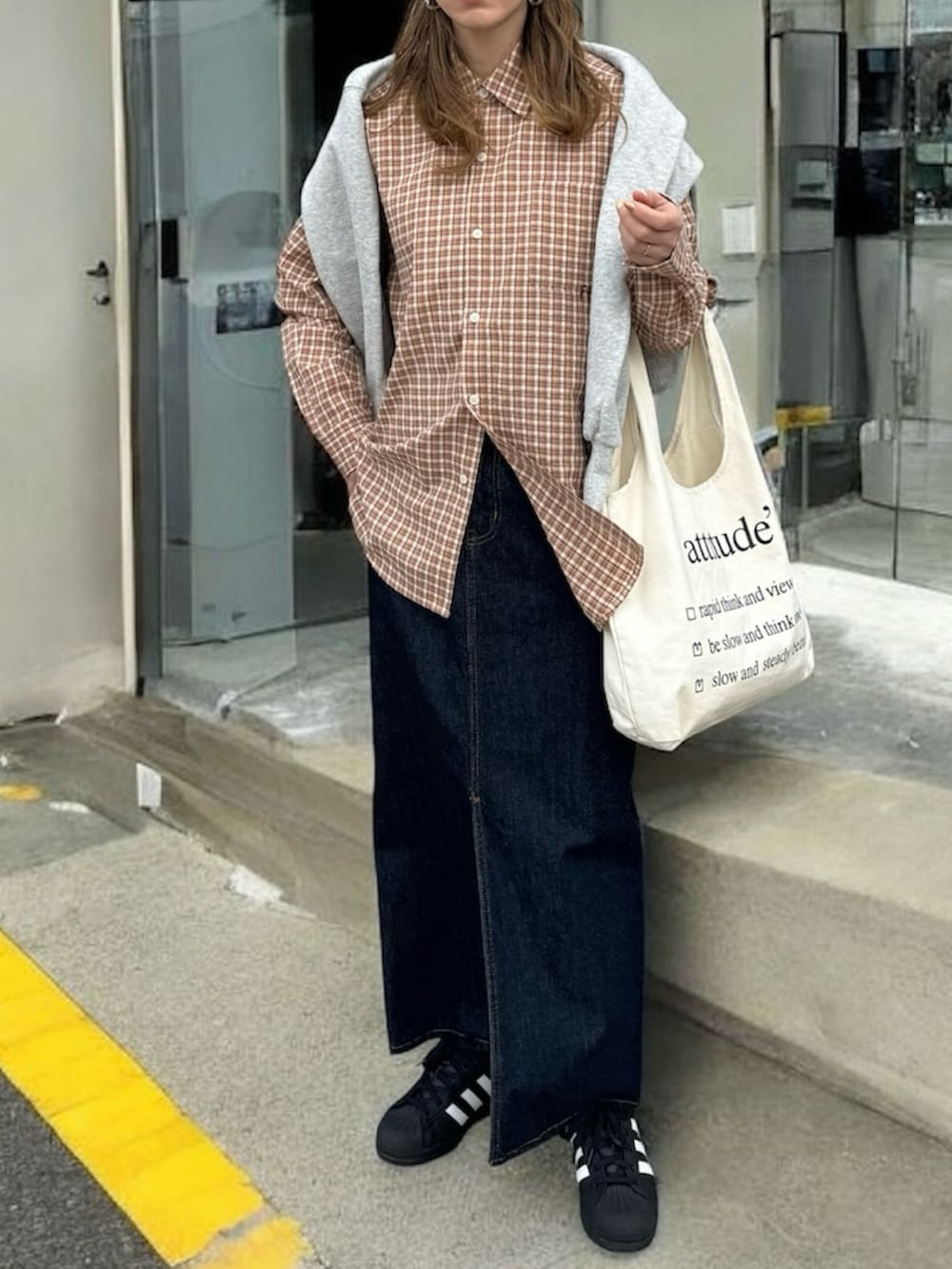 ブラウン系のシャツ/ブラウス、ブルー系のデニムスカート、ブラック系のスニーカーを着用したレディースの春コーディネートの3枚目の写真