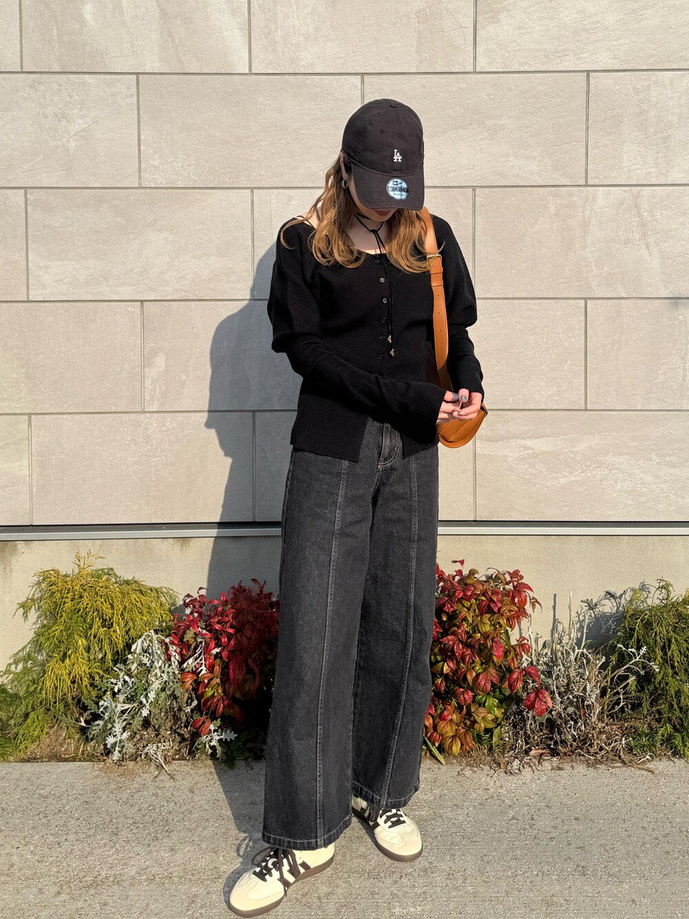 ブラック系のカーディガン/ボレロ、ブラック系のデニムパンツ、ベージュ系のスニーカーを着用したレディースの春コーディネートの2枚目の写真