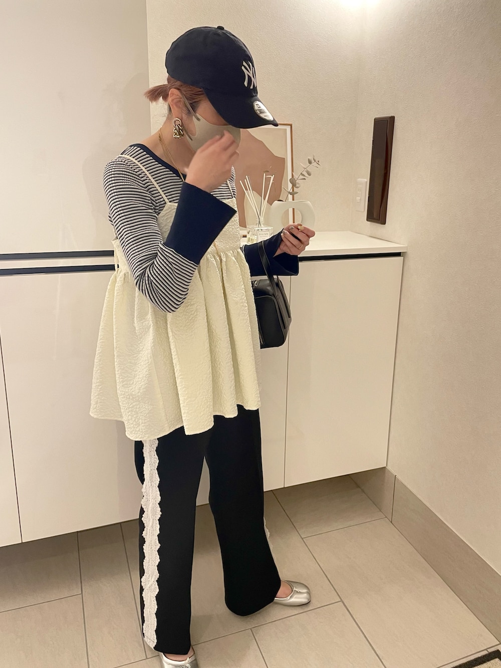 ホワイト系のキャミソール、ブラック系のその他パンツ、ブルー系のニット/セーターを着用したレディースの春コーディネートの2枚目の写真