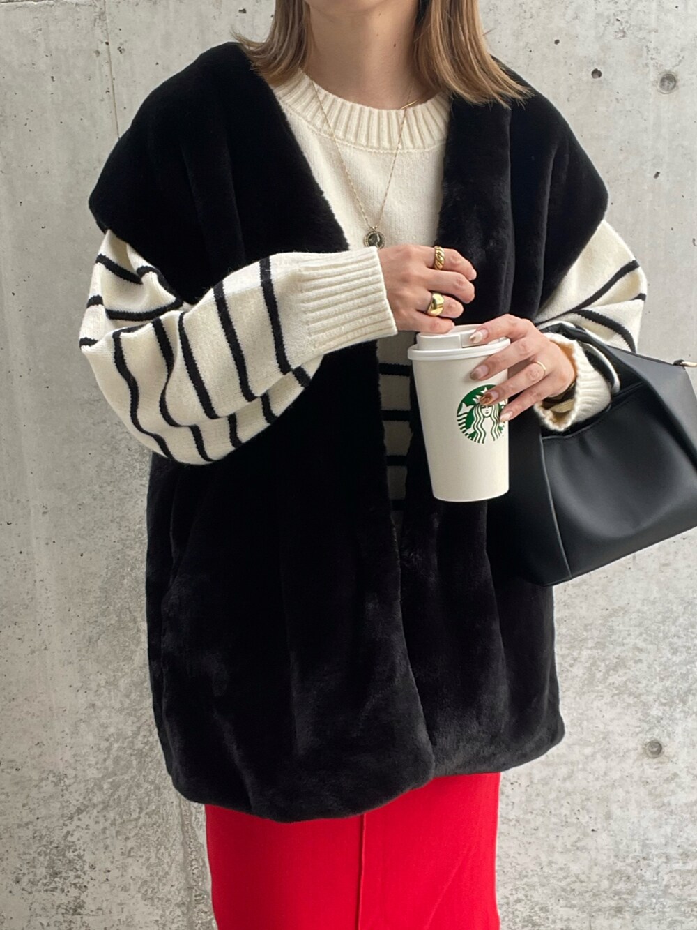 ホワイト系のニット/セーター、ブラック系のベスト、レッド系のスカートを着用したレディースの秋コーディネートの3枚目の写真