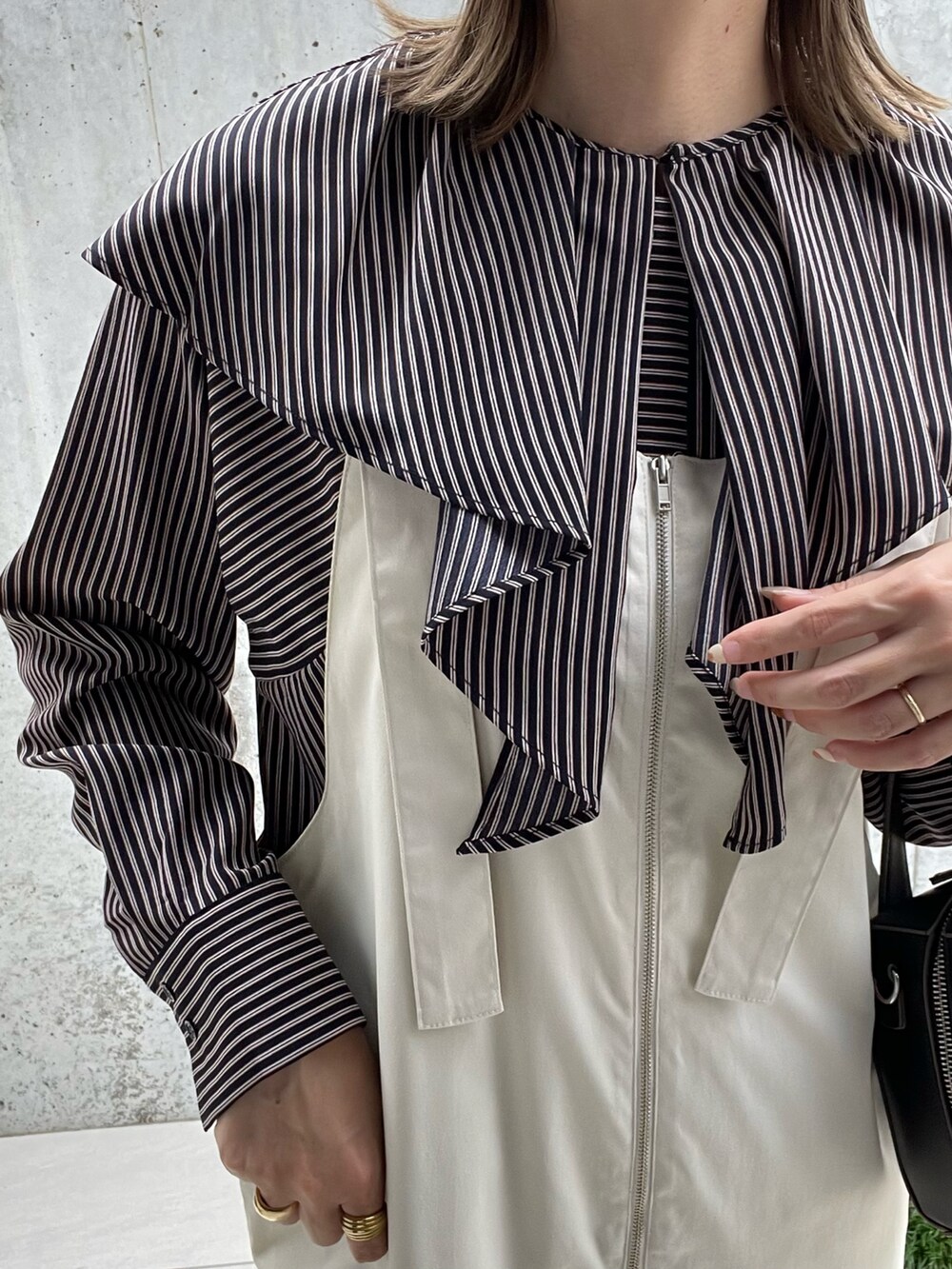 ブルー系のシャツ/ブラウス、ホワイト系のサロペット/オーバーオール、ブラック系のボストンバッグを着用したレディースの秋コーディネートの5枚目の写真