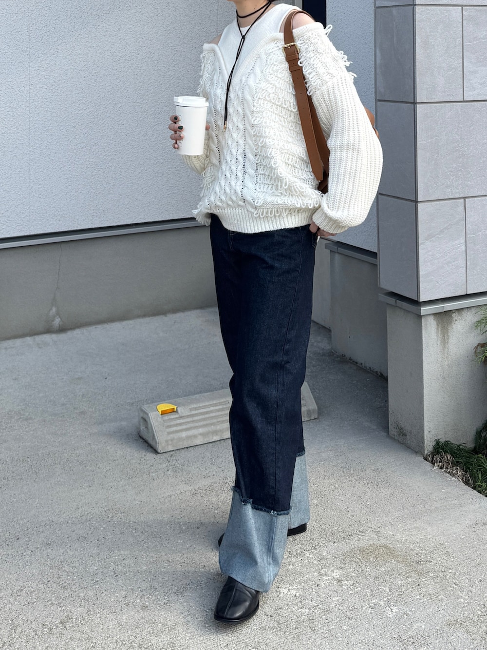 ブルー系のデニムパンツ、ベージュ系のショルダーバッグ、ホワイト系のニット/セーターを着用したレディースの秋コーディネートの3枚目の写真