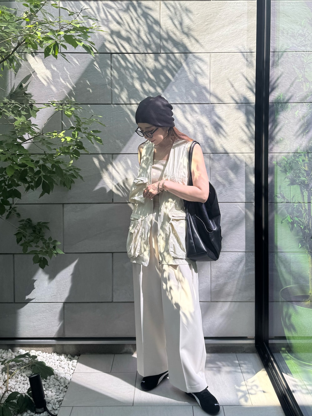 ホワイト系のベスト、ホワイト系のその他パンツ、ブラック系のスニーカーを着用したレディースの夏コーディネートの2枚目の写真